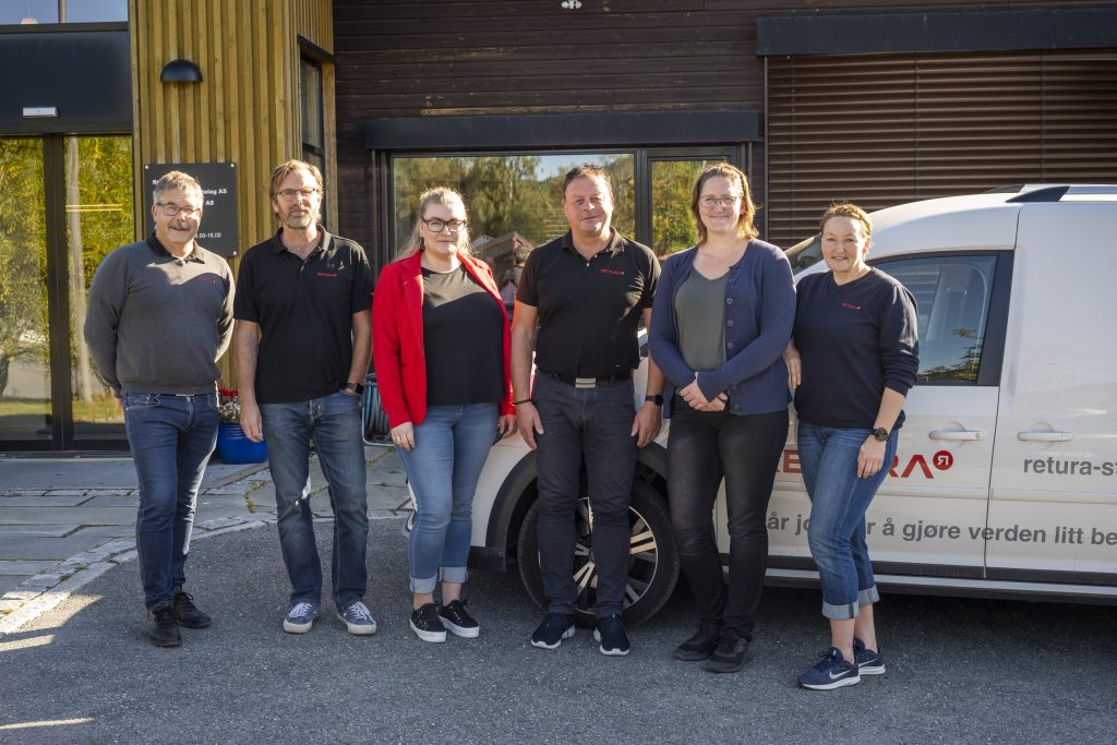 Bilde av Jon, Ketil, Ida Marie, Fredrik, Marion og Lise. De står foran en hvis bil, som har logoen til Retura på seg. Det står også på bilen, at vår jobb er å gjøre verden litt bedre.