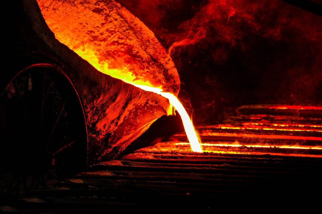 Bilde av noen som heller flytende metall for å lage nye produkter. Ser ut som glødende lava.